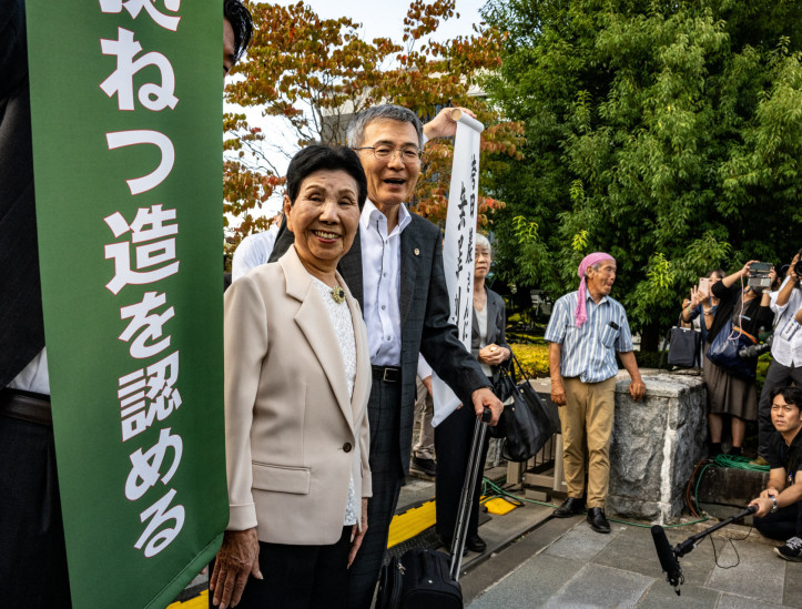 Hideko Hakamada (C), irmã de Iwao, e advogados posam com uma faixa branca com os dizeres 