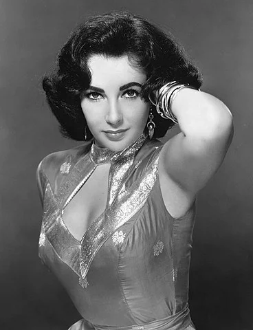 Elizabeth Taylor (1932-2011).  Nascida em Londres, ela começou a carreira aos 10 anos e manteve a atividade até 2003 (71 anos de trabalho em teatro e cinema).  Em Hollywood, protagonizou grandes clássicos, como Cleópatra. Ganhou 2 Oscars. 
