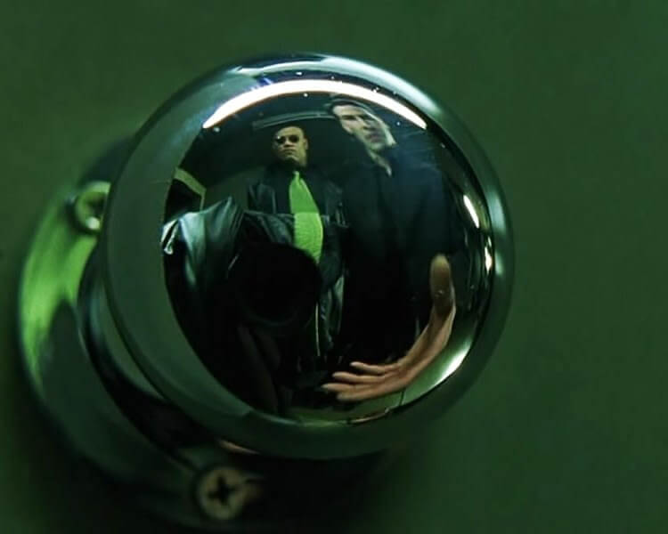 “Matrix” (1999): Nessa cena, Morpheus diz a Neo a frase eu só posso te mostrar a porta, mas o que chamou a atenção aqui é o fato de não terem conseguido esconder a câmera na hora de filmar a maçaneta.