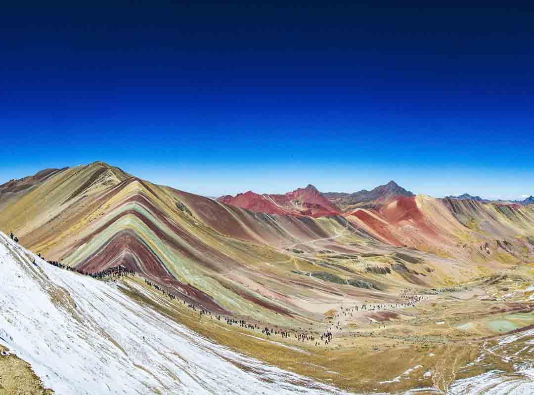Vinicunca, Peru: Localizada na cordilheira dos Andes, o lugar é um destino turístico popular, conhecido por suas cores vibrantes. As cores são causadas por diferentes minerais presentes nas rochas, como óxido de ferro, enxofre, cobre e manganês.