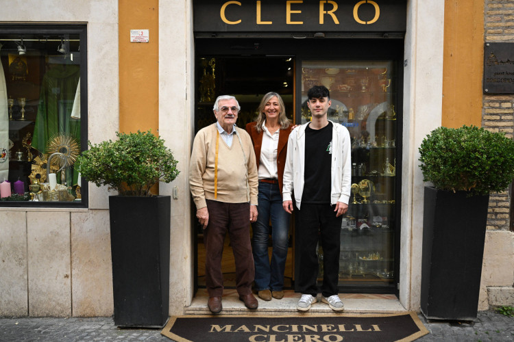 O alfaiate eclesi&aacute;stico italiano Raniero Mancinelli, 86 anos, posa com seu neto e sua filha do lado de fora de sua loja em Borgo Pio, bairro pr&oacute;ximo ao Vaticano, em Roma 