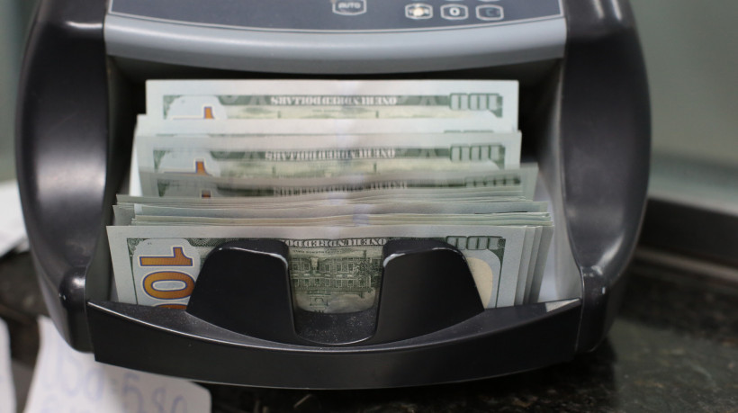 FORTALEZA-CE, BRASIL, 18.12.2024: Fotos de dólar e de alguém pegando no dólar, na casa de câmbio. (foto: Fabio Lima/ OPOVO)