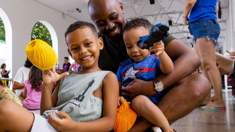 Fortaleza- CE, Brasil, 22-12-24: Oficina de bordado entretem crian&ccedil;as na Esta&ccedil;&atilde;o das Artes. Na foto, Gildas Mbemya com os filhos Johan (esq.) e Nathan (dir.). (Fotos: Lorena Louise / Especial para O POVO)  