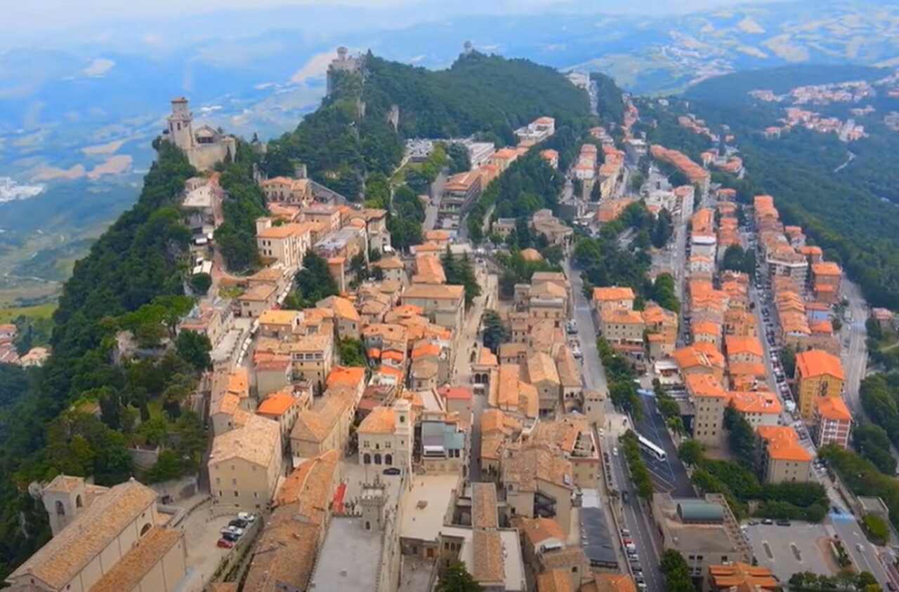 País: San Marino - Continente: Europa/ População: aproximadamente 34.000 habitantes/ Descrição: um dos menores países do mundo, São Marinho é um enclave na Itália, conhecido por sua rica história medieval e paisagens montanhosas. A economia é baseada em turismo e serviços