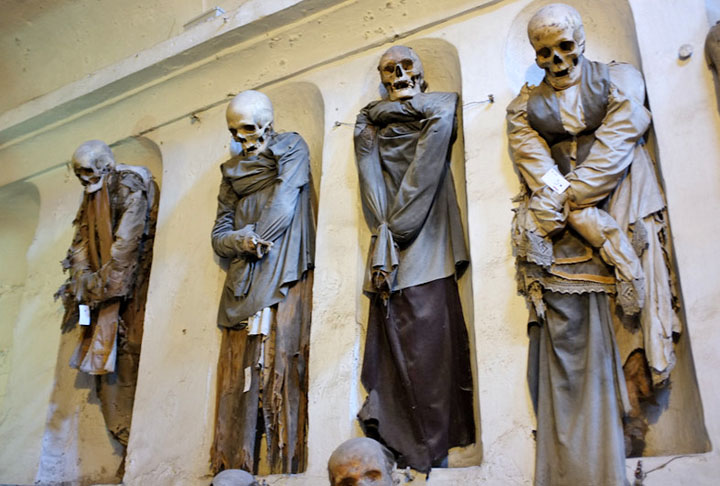 Com o tempo, foi preciso construir um cemitério e diz-se que, por milagre, muitos corpos mumificaram naturalmente. Por isso, eles passaram a ficar em pé, em nichos. Os corpos mumificados receberam roupas. Um cenário que espanta. 