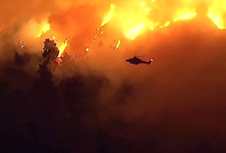 Bombeiros utilizam helicópteros e veículos para tentar conter as chamas, enquanto os incêndios continuam a se expandir pela região.