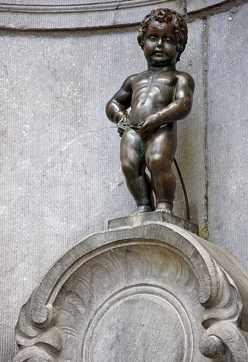 Manekken Pis - Bruxelas - Bélgica. Criada no início do século XVII, a pequena estátua de bronze retrata um menino urinando em uma fonte e é famosa por seu charme, digamos, peculiar. Situada na Place du Petit Sablon, a figura é frequentemente vestida com trajes diversos, refletindo o espírito irreverente da cidade.