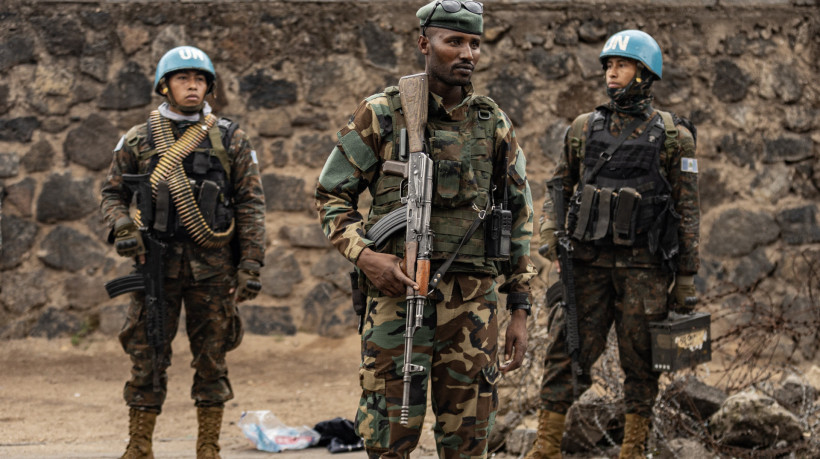 Um membro do grupo armado M23 (centro) está em frente a soldados guatemaltecos da Missão de Estabilização da Organização das Nações Unidas na República Democrática do Congo enquanto eles monitoram o acesso à passagem de fronteira para Ruanda, em Goma, em 29 de janeiro de 2025