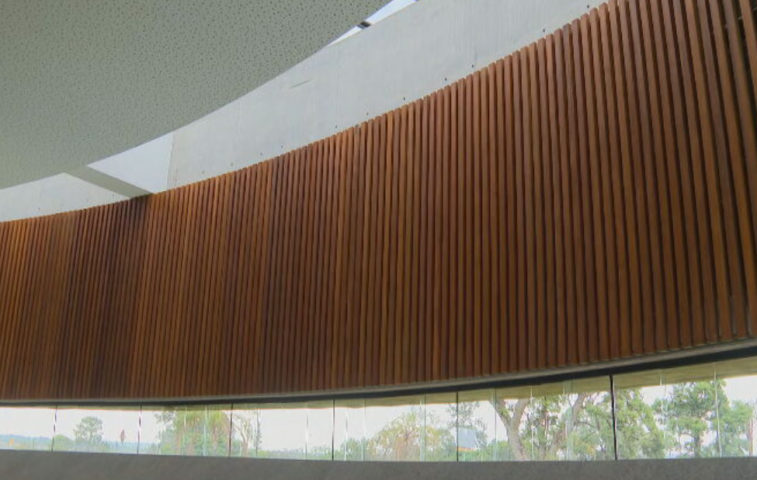 Revertidas de madeira, as paredes internas recebem o reflexo da luz natural vinda de uma ampla claraboia, criando um visual espetacular no interior da igreja.