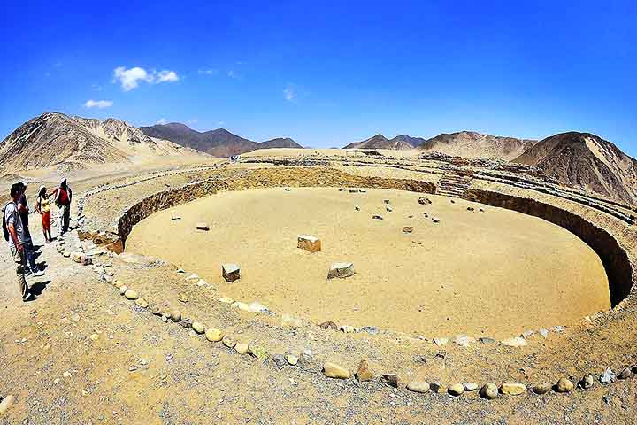 Ao lado dele encontra-se uma praça rebaixada com escadarias alinhadas e grandes monólitos, símbolos de poder e espiritualidade, informa o perfil do X da Zona Arqueológica de Caral. 
