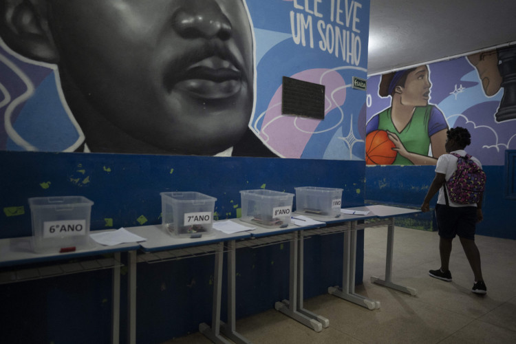 Uma estudante caminha até sua sala de aula depois de deixar seu celular em uma caixa no início do dia letivo na escola pública Reverendo Martin Luther King, no Rio de Janeiro 