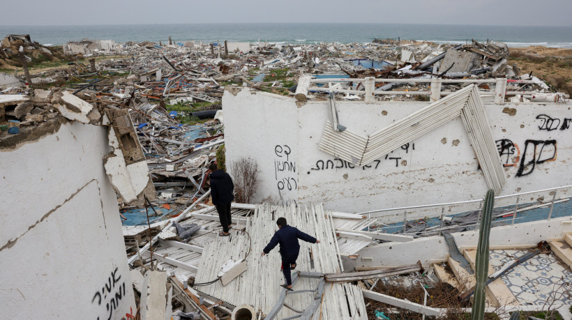 Jovens caminham entre os escombros do destruído Bianco Resort, no oeste de Gaza, em 11 de fevereiro de 2025, em meio ao atual acordo de cessar-fogo na guerra entre Israel e o Hamas 
