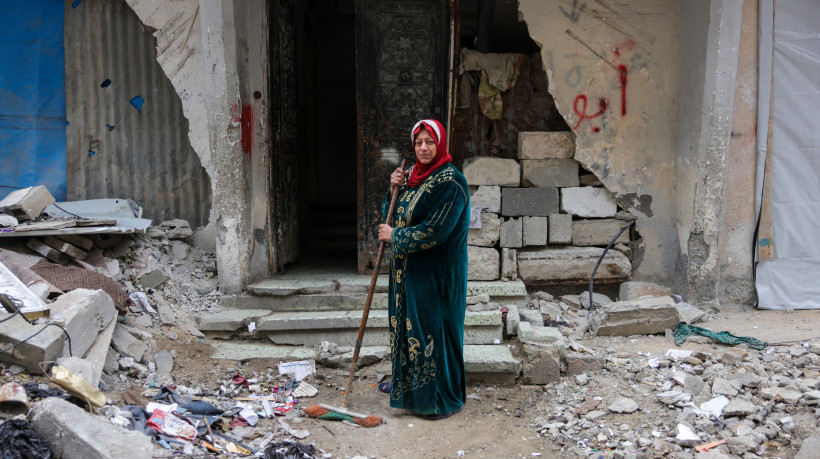 Shahira Sammour, 49 anos, posa em frente à sua casa destruída em Jabalia, norte da Faixa de Gaza, em 9 de fevereiro de 2025
