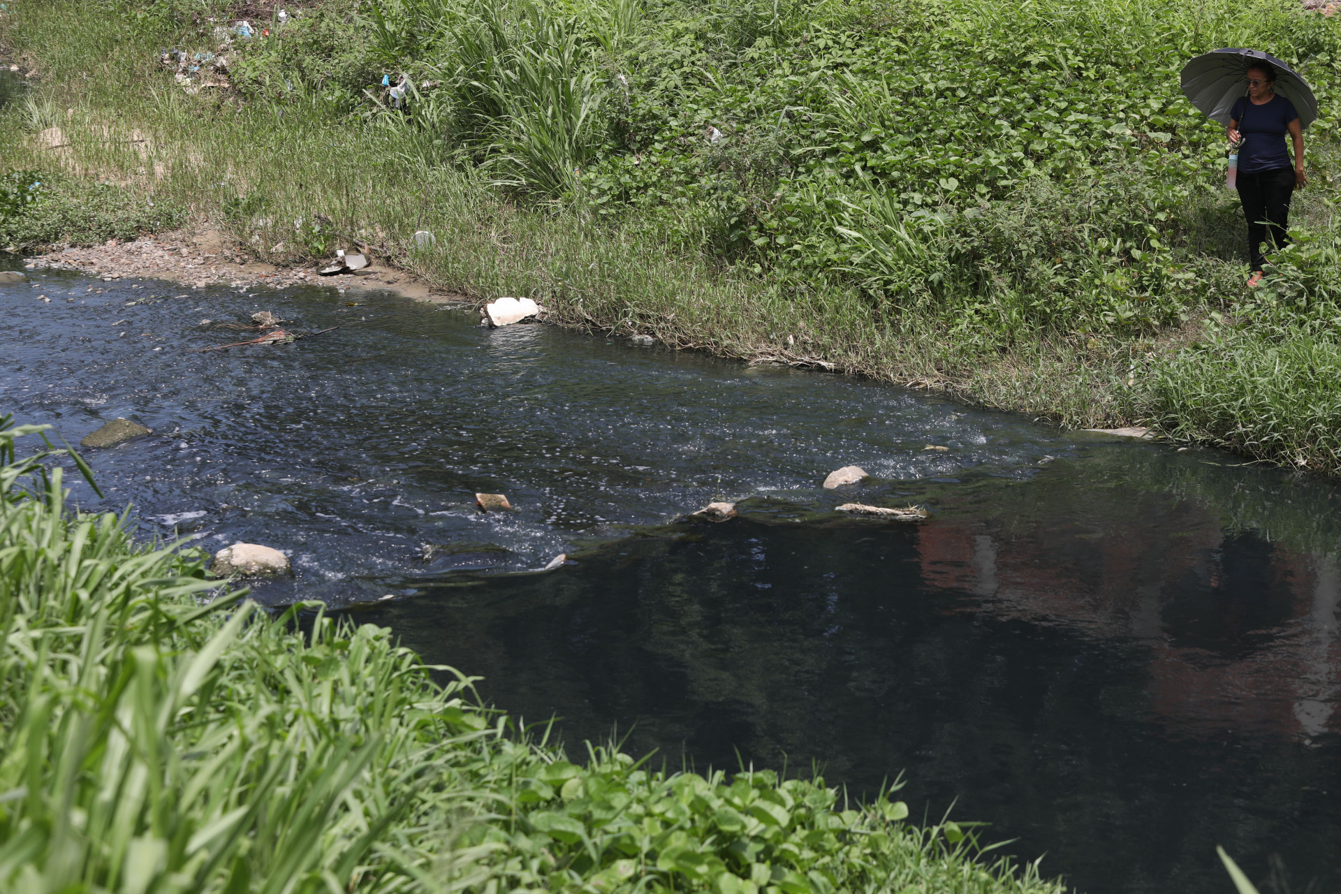 Estudantes e moradores atravessam c&oacute;rrego, por falta de ponte sobre o rio Maranguapinho 