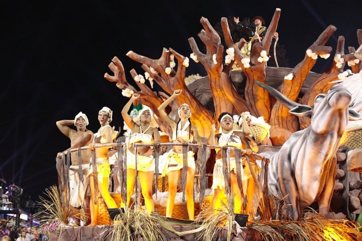 Em Cima da Hora - Esta escola do bairro Cavalcanti, da Zona Norte do RJ, carrega as cores azul-pavão e branco. Será a 7ª escola a desfilar com o enredo Ópera dos Terreiros - O Canto do Encanto da Alma Brasileira.