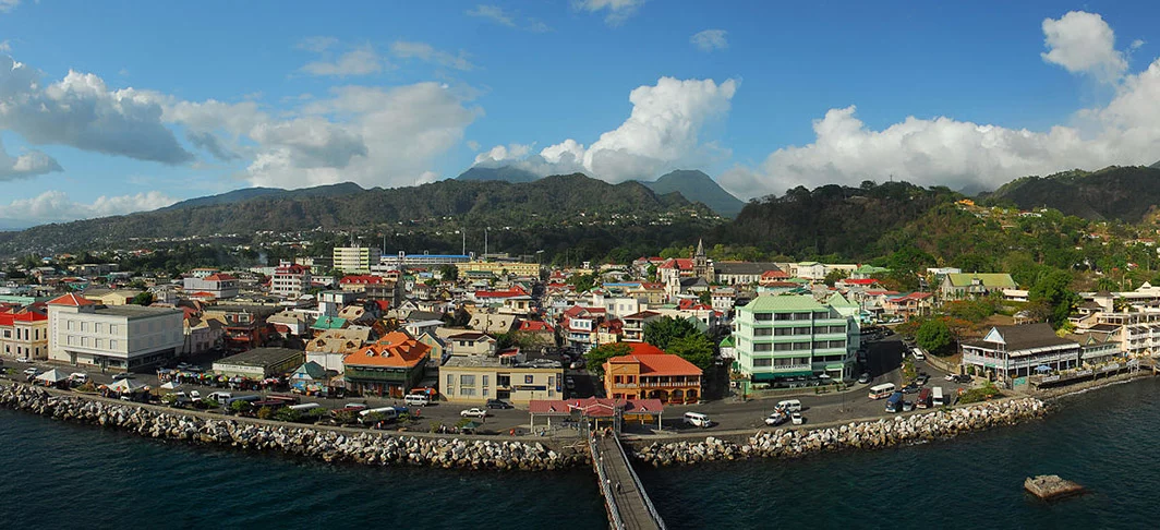 Dominica - País insular montanhoso, no Caribe, tem florestas e fontes térmicas. O Lago Boiling tem vulcão e é coberto de vapor, no Parque Morne Trois Pitons. A capital Roseau tem casas coloridas de madeira e jardins botânicos. 