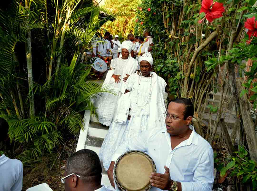 Arroboboi, presente no refrão, é um saudação e evocação da energia que transita entre o céu e a terra. A entidade presente no encantamento do arco-íris, que seria a ponte sagrada que liga os humanos às divindades Voduns. Um culto recheado de ensinamentos das eternas herdeiras de Dangbé. 