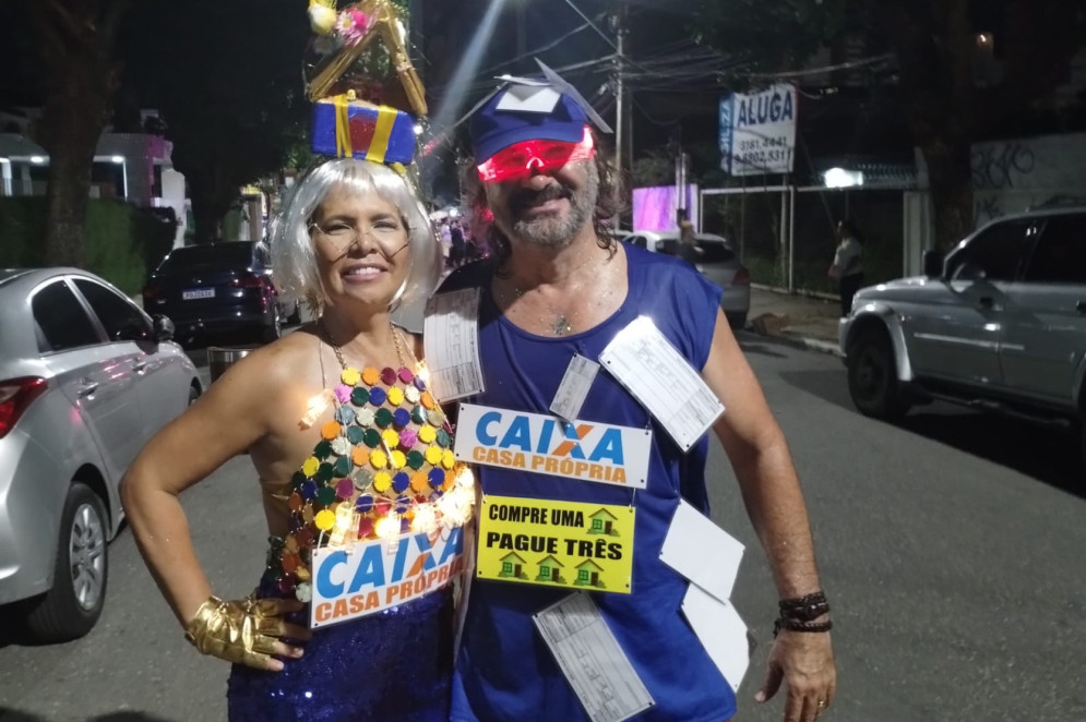 André e Adriana estavam com fantasias em tom de protesto; ele de boleto e ela de casa própria, no polo da Mocinha 