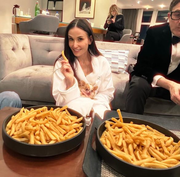 Em uma foto postada por sua filha, Moore aparece sentada no chão de roupão, com seu cachorro no colo e com duas tigelas cheias de batata frita ao lado. 