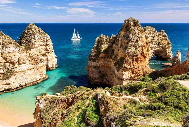Portugal - Destinos como Algarve e Madeira possuem falésias e grutas naturais deslumbrantes. Além das belezas naturais, a cultura e gastronomia enriquecem a viagem. Um destino ideal para quem busca paisagens únicas.