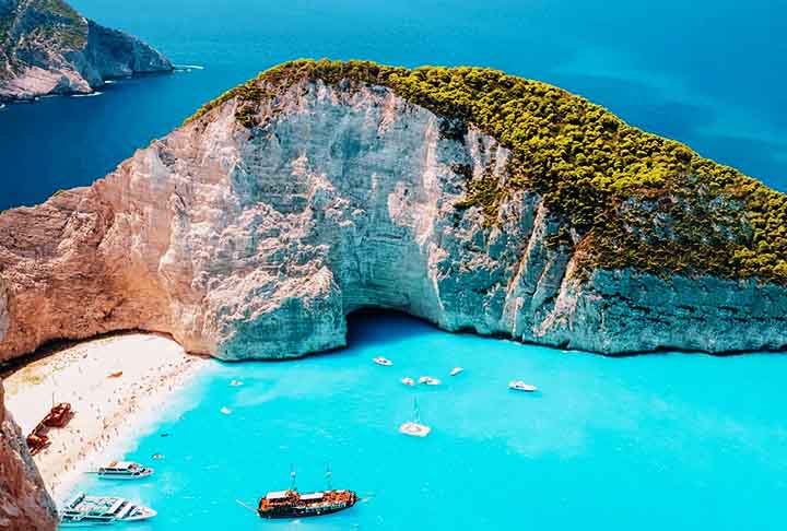 Grécia - Destinos como Mykonos e Santorini oferecem águas cristalinas e paisagens únicas. O charme mediterrâneo e a história tornam a experiência inesquecível. Turismo relaxante e vida noturna agitada atraem visitantes.