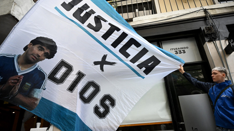 Torcedor segura bandeira com a imagem de Diego Maradona em frente ao tribunal de San Isidro antes do julgamento pela morte da lenda do futebol argentino 