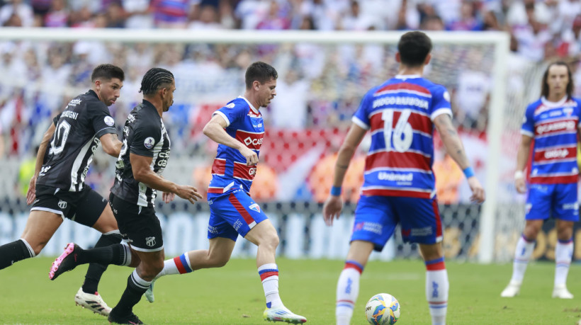 Matheus Rossetto conduz a bola sendo marcado por Fernando Sobral e Mugni