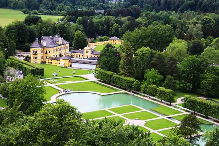 Já o Palácio de Hellbrunn, construído no século XVII, é famoso por seus jardins exuberantes e suas fontes “mágicas” interativas. Encomendado pelo Príncipe-Arcebispo Markus Sittikus como um palácio de verão, o local surpreende os visitantes com fontes escondidas que pegam as pessoas de surpresa.