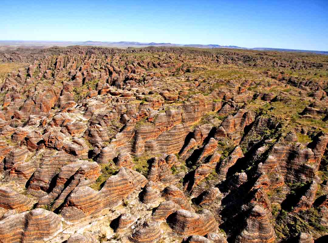 Cordilheira Bungle Bungle, Austrália: Localizada no Parque Nacional Purnululu, na região de Kimberley, na Austrália Ocidental, essa cordilheira é composta por domos de arenito laranja e preto que se erguem do solo do deserto.