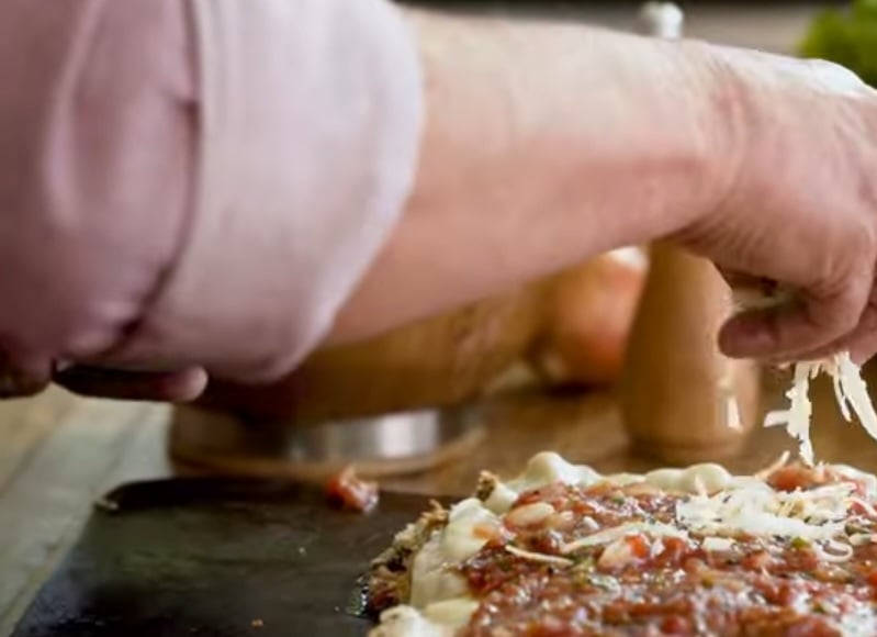 Espalhe o molho e coloque o churrasco em cima.  Cubra com um pouco mais de molho e espalhe um pouco de queijo parmesão por cima. Está pronto.