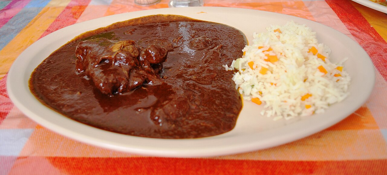 México - Mole Poblano: Um molho espesso e rico que combina pimentas secas (como ancho e mulato), especiarias e chocolate, servido com carne.
