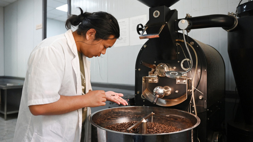 Liao Shihao verifica os grãos após a torra na plantação de café Xiaowazi, ou Pequeno Oco, em Pu'er, na província de Yunnan, sudoeste da China. Região deu nome a um tipo de chá ricamente fermentado — às vezes chamado de 