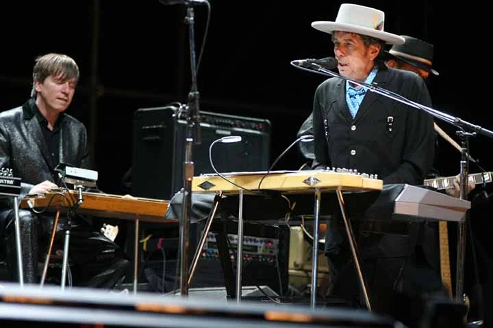 Bob Dylan: Artista múltiplo nascido em 24/05/1941, no estado do Minnesota. Autor de canções célebres, como “Like a Rolling Stone” e “Blowin’ in the Wind”. Único artista a ganhar os quatro prêmios mais badalados da arte mundial - Nobel, Pulitzer, Oscar e Grammy -, é multi-instrumentista - toca guitarra, gaita e piano.
