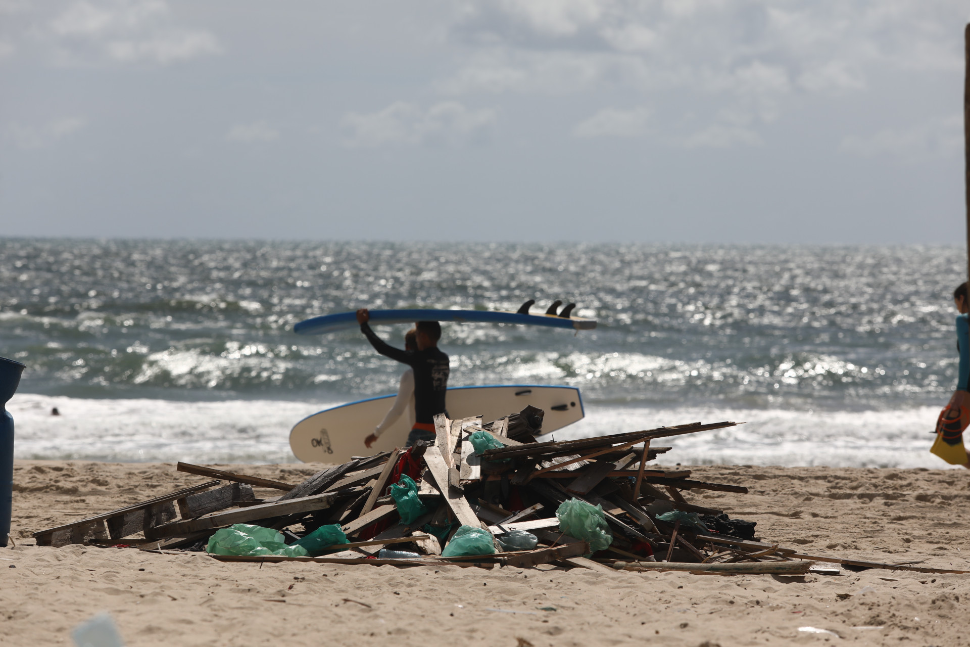 Homem reconstrói barraca derrubada ontem. Retirada de barracas irregulares na Praia do Futuro em operação da SPU