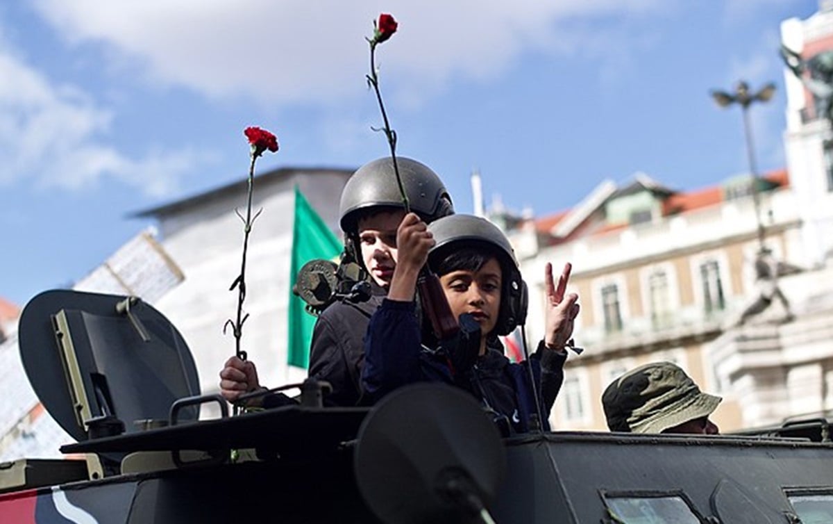 O nome Revolução dos Cravos se popularizou porque os soldados do exército português que derrubaram o regime de Salazar receberam cravos vermelhos e colocaram no cano de suas armas, desfilando pelas ruas. Até hoje, o gesto é repetido nas celebrações.