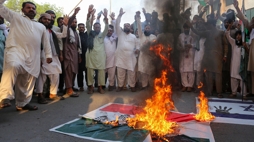 Manifestantes queimam uma faixa com a imagem da bandeira nacional da Índia 