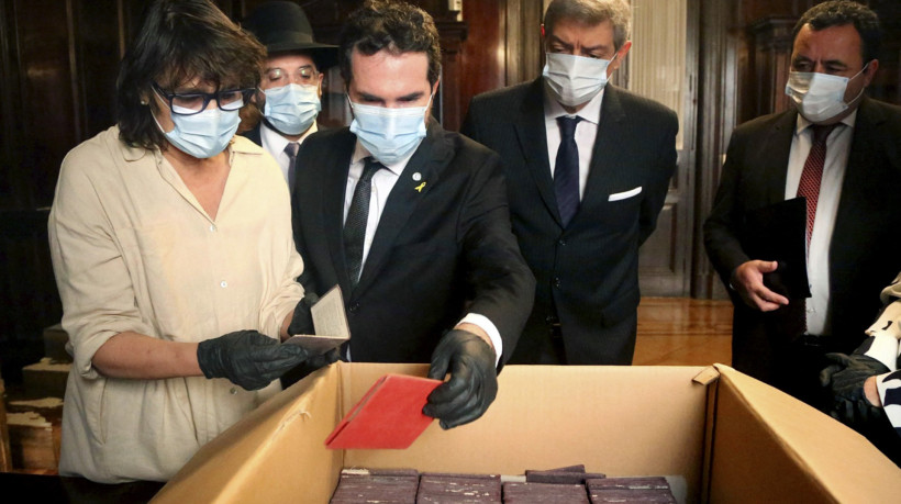 Foto divulgada em 11 de maio de 2025 pela Suprema Corte da Argentina mostrando a pesquisadora do Museu do Holocausto de Buenos Aires, Marcia Ras (esquerda), e o diretor executivo do Museu do Holocausto de Buenos Aires, Jonathan Karszenbaum (centro), verificando documentação nazista ao lado do rabino-chefe da Asociacion Mutual Israelita Argentina, Eliahu Hamra, do presidente da Suprema Corte, Horacio Rosatti, e do diretor do Centro de Assistência Judicial Federal (CAJF), ​​Pablo Lamounant, após a descoberta de várias caixas armazenadas no porão do Palácio da Justiça, em Buenos Aires