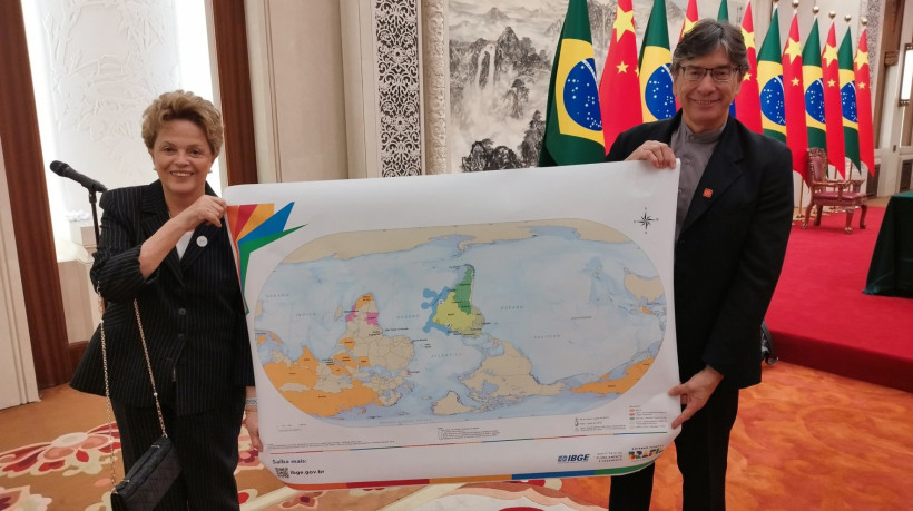 Dilma e Marcio Pochmann com mapa-múndi com orientação Sul-Norte no lugar da convencional