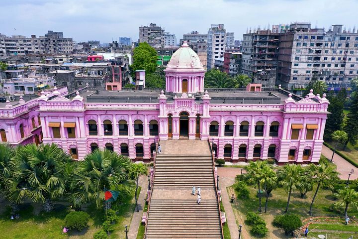 Apesar da superlotação, a cidade é o coração da indústria têxtil de Bangladesh, um dos maiores exportadores de roupas do mundo, além de abrigar monumentos como o Forte de Lalbagh, mesquitas centenárias e o Palácio Ahsan Manzil.