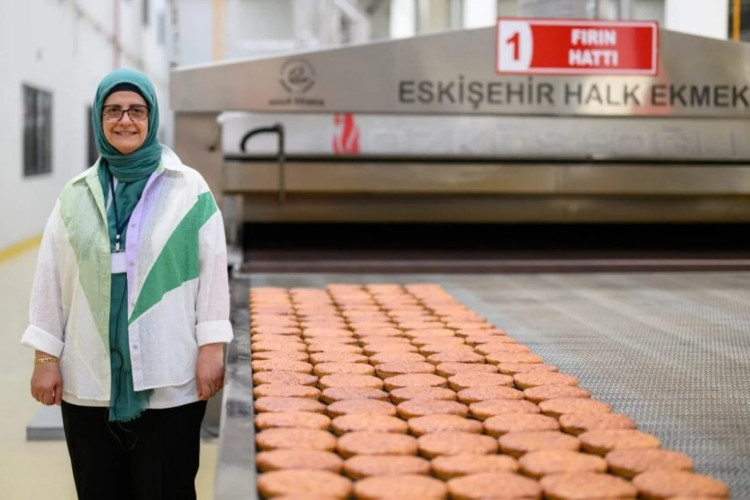 Serap Güler, gerente da Halk Ekmek (Pão Público, em turco) ao lado de pães Kulluoba cozidos, uma reprodução de um pão de 5.000 anos.