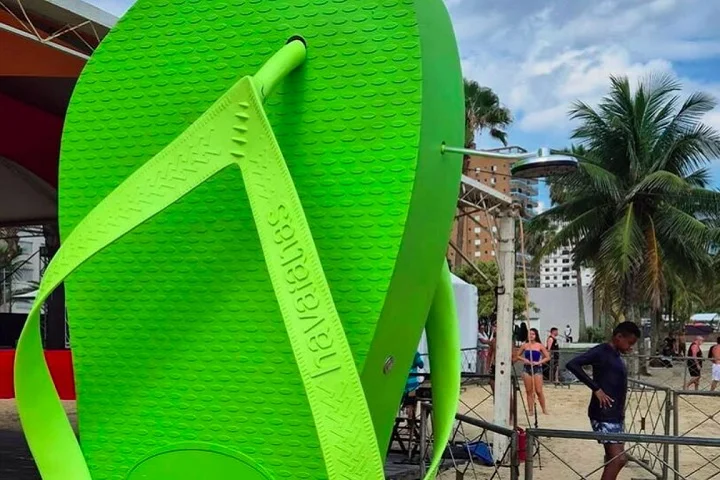 Um chuveirão de 3 metros de altura em formato de chinelo gigante foi colocado na areia da praia, chamando a atenção dos turistas.