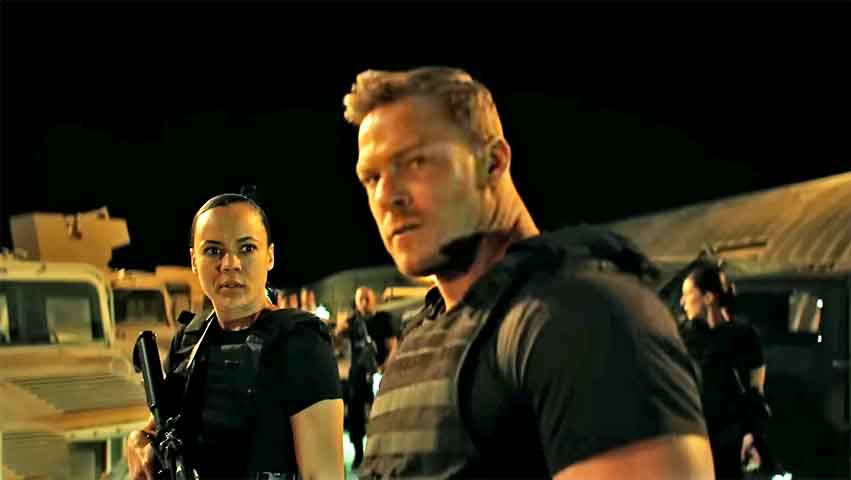 Alto, forte, enigmático e carismático, Ritchson consegue equilibrar a brutalidade do personagem com momentos de ironia e sensibilidade contida.