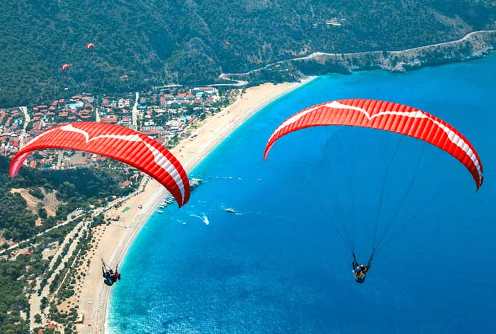 11º) Parapente Duplo Fethiye, Turquia - Partindo da montanha de Babadağ, uma das mais populares para salto de parapente no mundo, os turistas passam por cima de uma praia com águas azuis até pousarem na areia. 