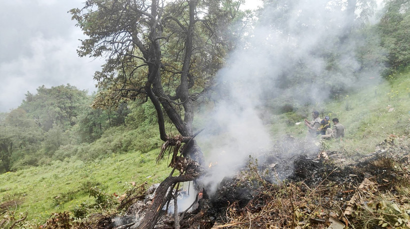 Esta fotografia, tirada em 15 de junho de 2025 e divulgada pela Força Estatal de Resposta a Desastres (SDRF) do estado de Uttarakhand, na Índia, mostra fumaça saindo do local da queda de um helicóptero perto de Gaurikund. Sete pessoas, incluindo uma criança, morreram