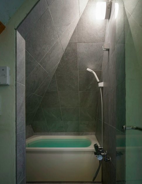 A distribuição dos cômodos foi pensada para otimizar o uso. O banheiro, que fica no 3º andar, aproveita o formato inclinado do telhado. A banheira foi encaixada entre as paredes, economizando espaço.