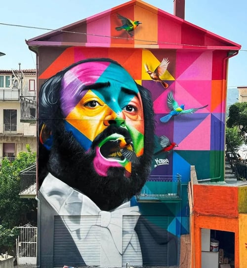 Kobra também tingiu um mural retratando o tenor italiano Luciano Pavarotti (1935-2007)  na cidade de San Pietro Magisano, na Calábria, sudoeste da Itália. A região é a terra natal dos antepassados do muralista brasileiro.
