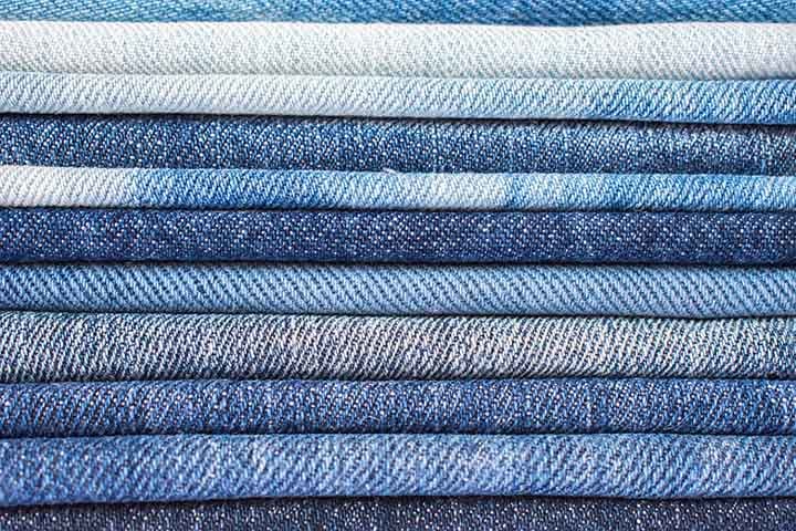 Jeans (Denim): Feito de algodão com trama sarjada, é resistente e durável. Originalmente usado como roupa de trabalho, tornou-se um ícone da moda casual em calças, jaquetas e saias. Sua versatilidade permite diversos acabamentos e estilos.
