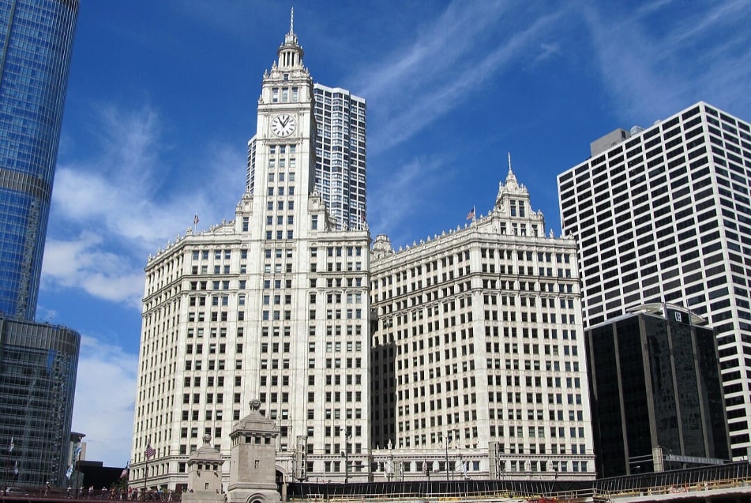 O Wrigley Building é um dos marcos arquitetônicos mais icônicos de Chicago, inaugurado em 1924 às margens do rio Chicago. Inspirado na Giralda de Sevilha, seu design mescla o estilo renascentista espanhol com toques modernos e uma fachada de terracota branca. Foi construído para sediar a sede da Wrigley Company, famosa pelos chicletes.
