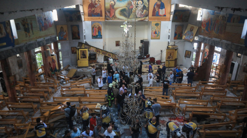 Pessoas e equipes de resgate inspecionam os danos no local de um suposto ataque suicida na igreja de Santo Elias, na área de Dwelaa, em Damasco, em 22 de junho de 2025.