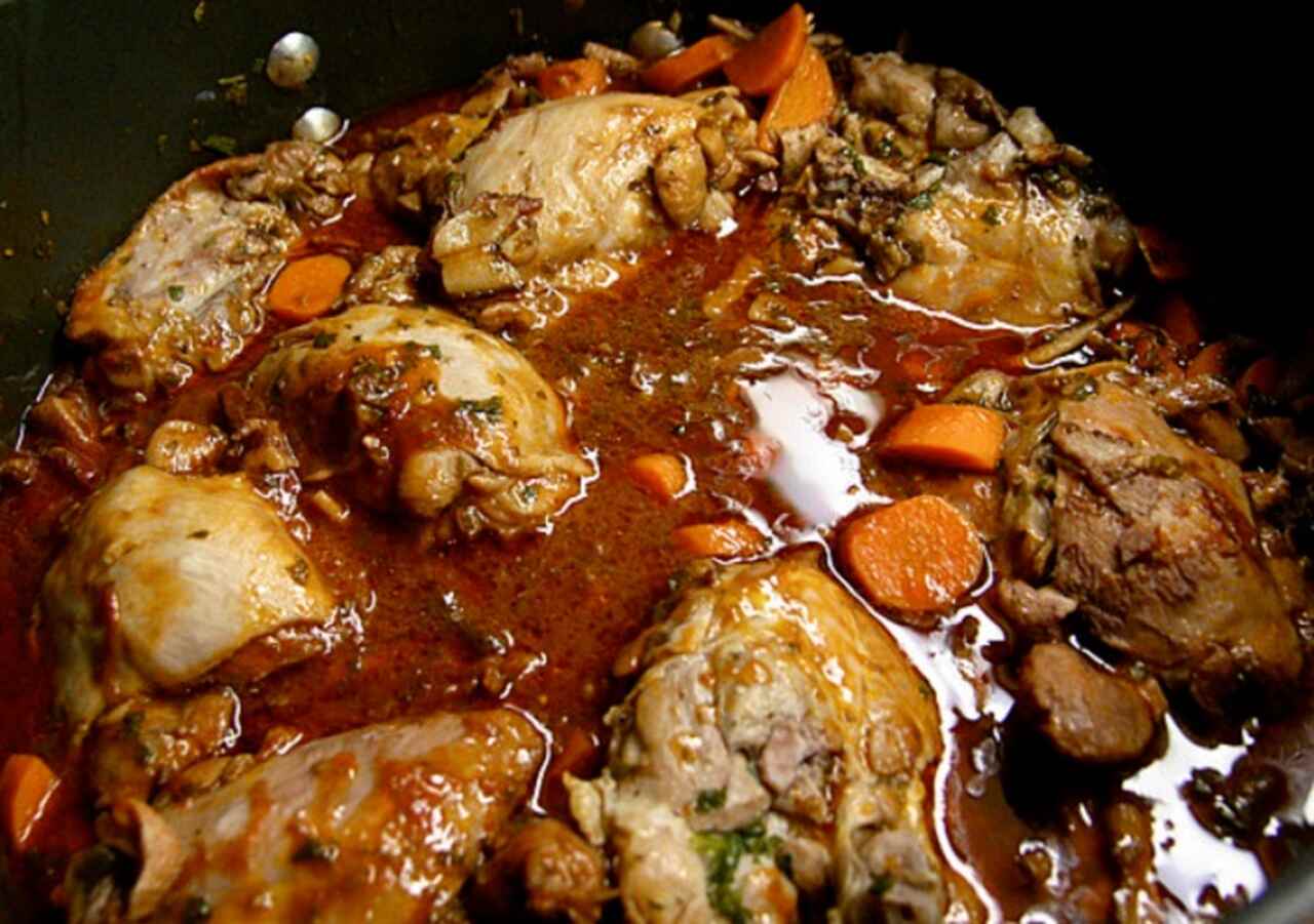 Coq au Vin - Um ensopado de frango cozido em vinho tinto, geralmente acompanhado de cogumelos, cebolas e bacon